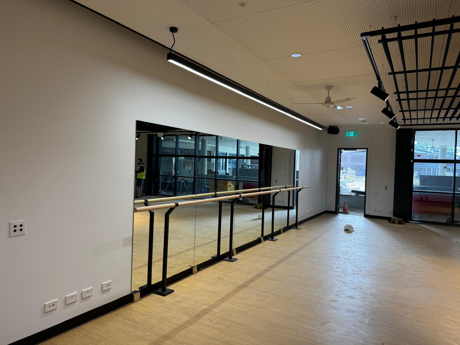 Side angle of ballet studio mirror wall Sydney with barres in school dance room