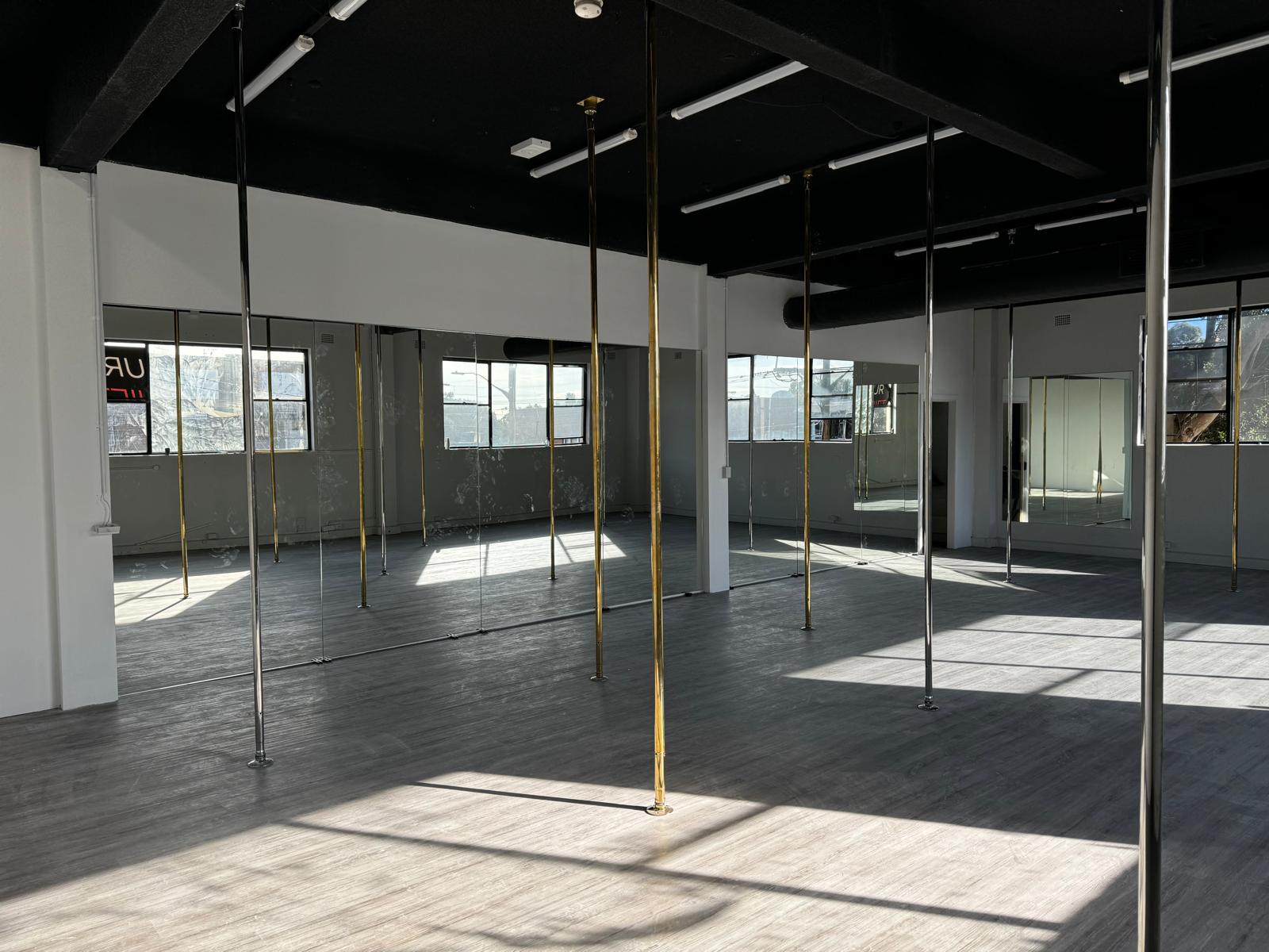 studio mirror wall Sydney with poles for dance and fitness training