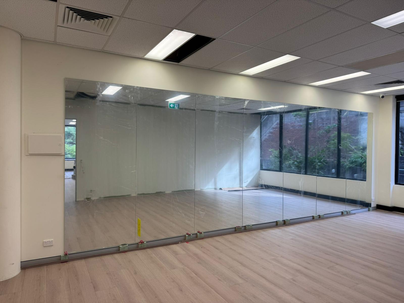 Large commercial mirror wall installation Sydney with full height frameless mirror panels