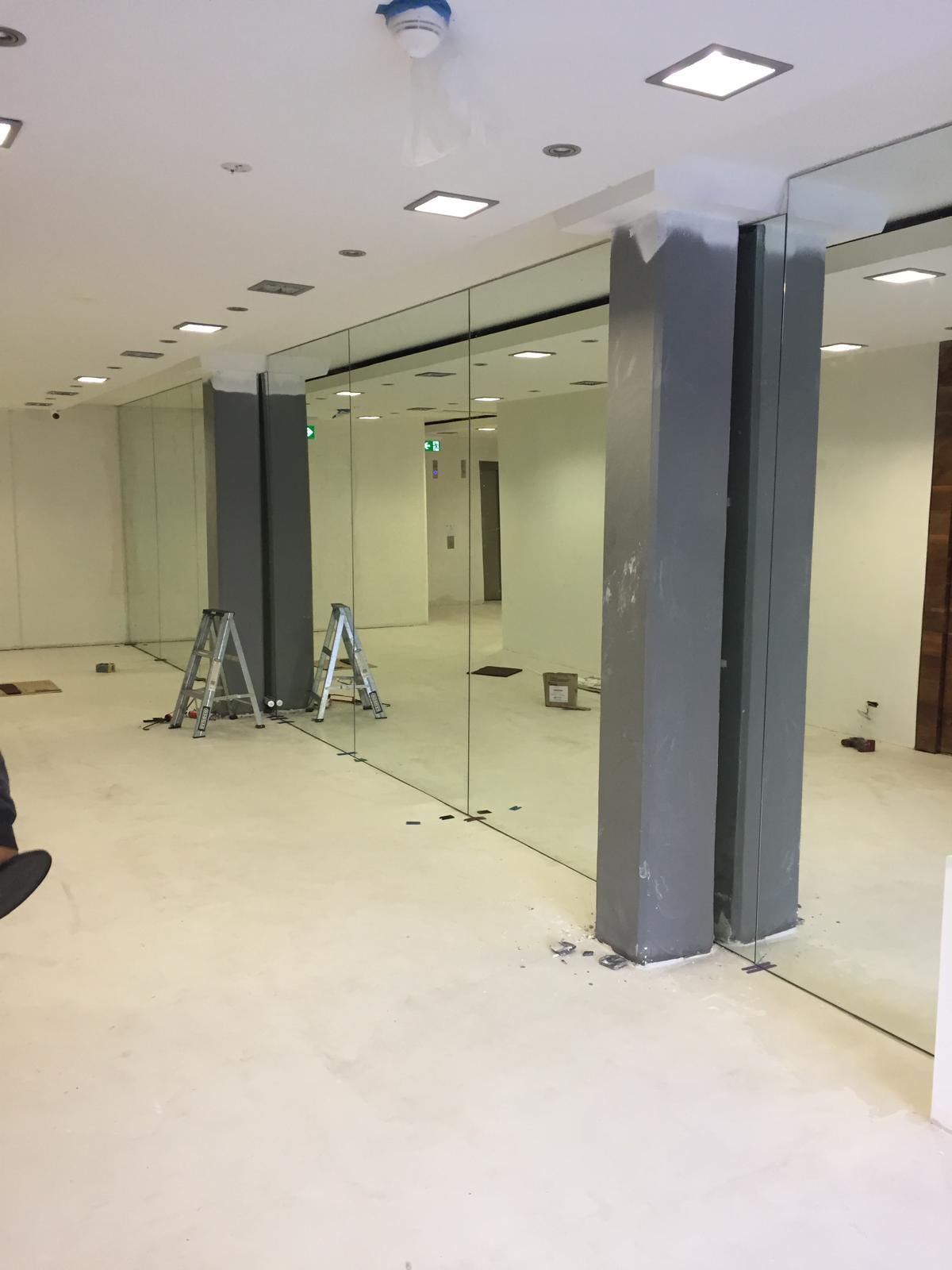 Full height lobby mirror wall installation in Sydney commercial building with frameless floor to ceiling mirrors